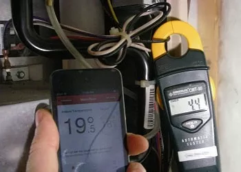 hvac tech measuring how many watts to run an electric furnace