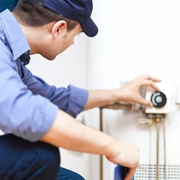 plumber turning dial on water heater
