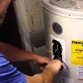 plumber replacing a thermostat on a water heater