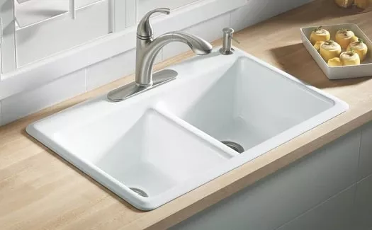 cast iron sink installation demonstrating difference between cast iron vs. fireclay sink